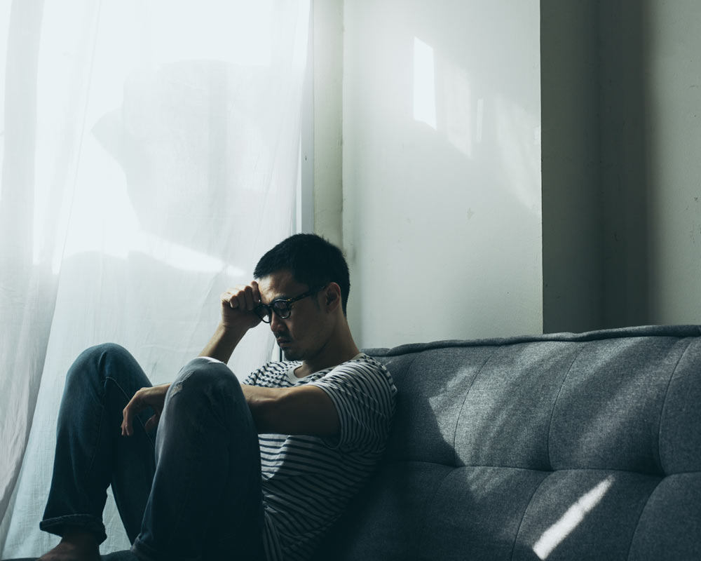 man on sofa, struggling with anxiety